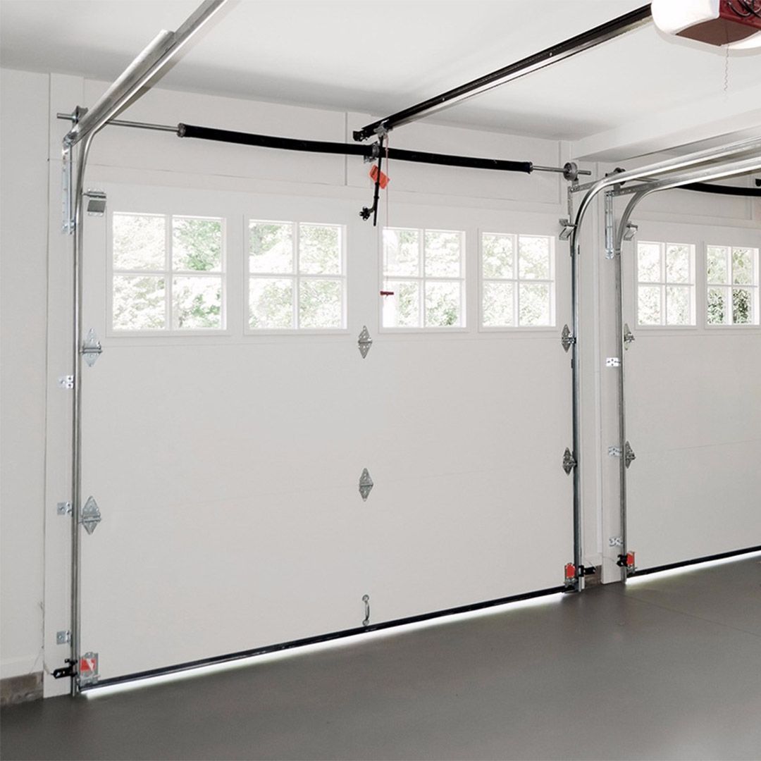 An indoor view of a white double garage door with windows.