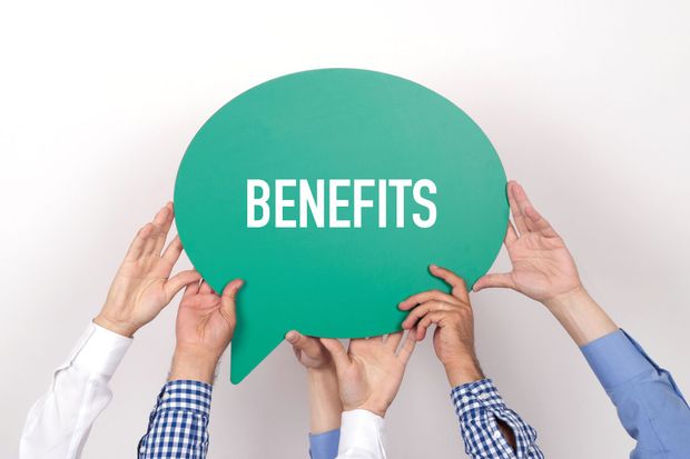 A group of people are holding a green speech bubble with the word benefits written on it.