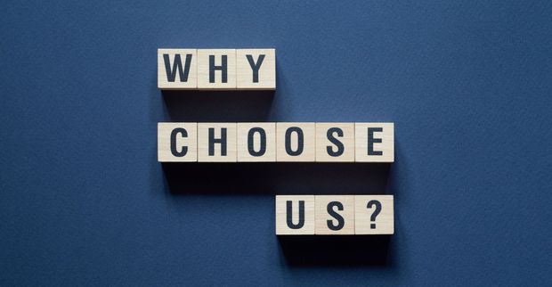 Why choose us is written on wooden blocks on a blue background.