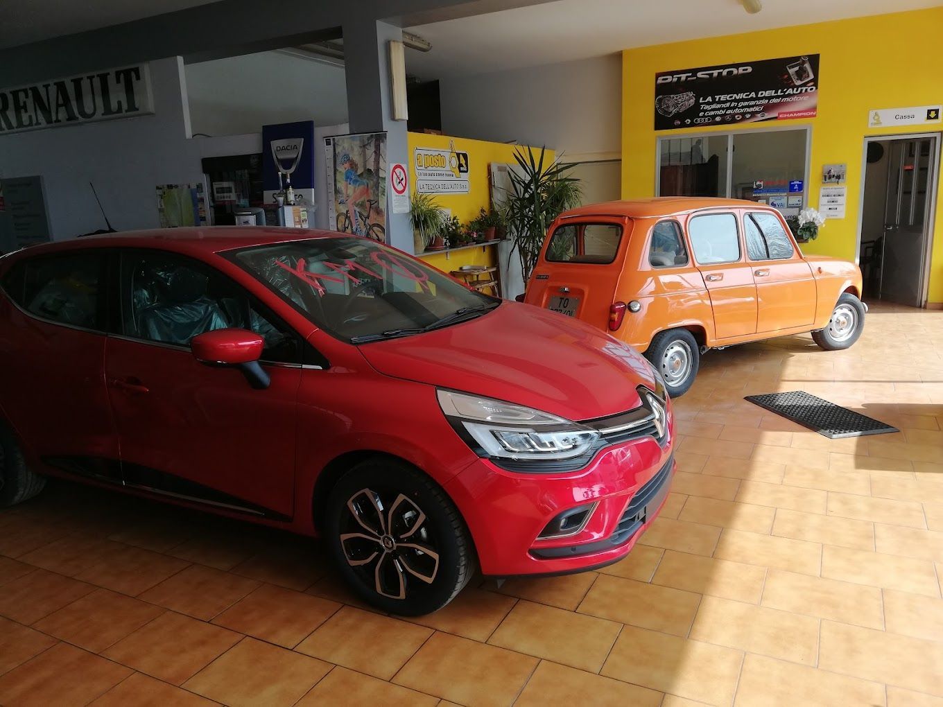 una macchina rossa è parcheggiata in un'officina