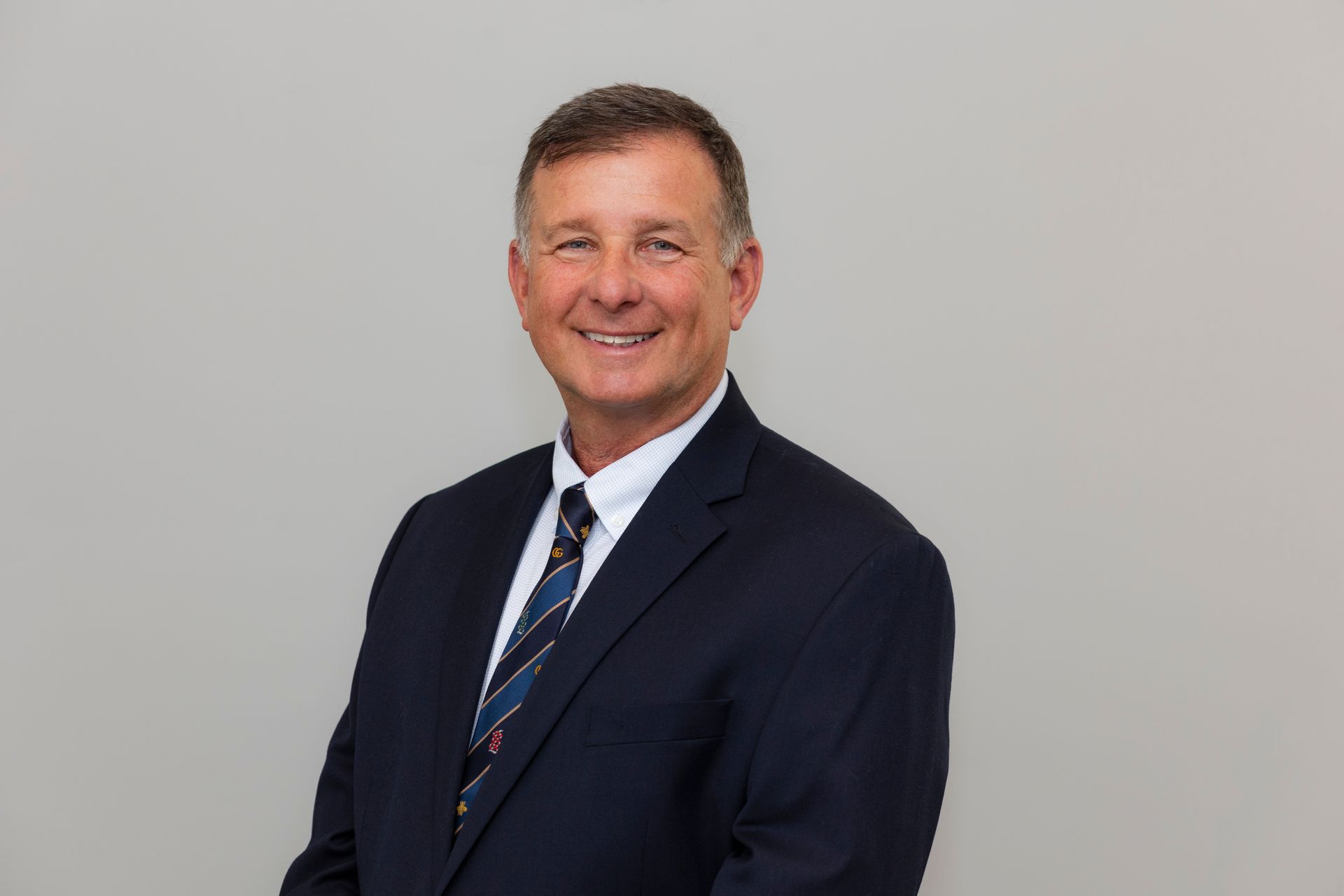 A man in a suit and tie is smiling for the camera.