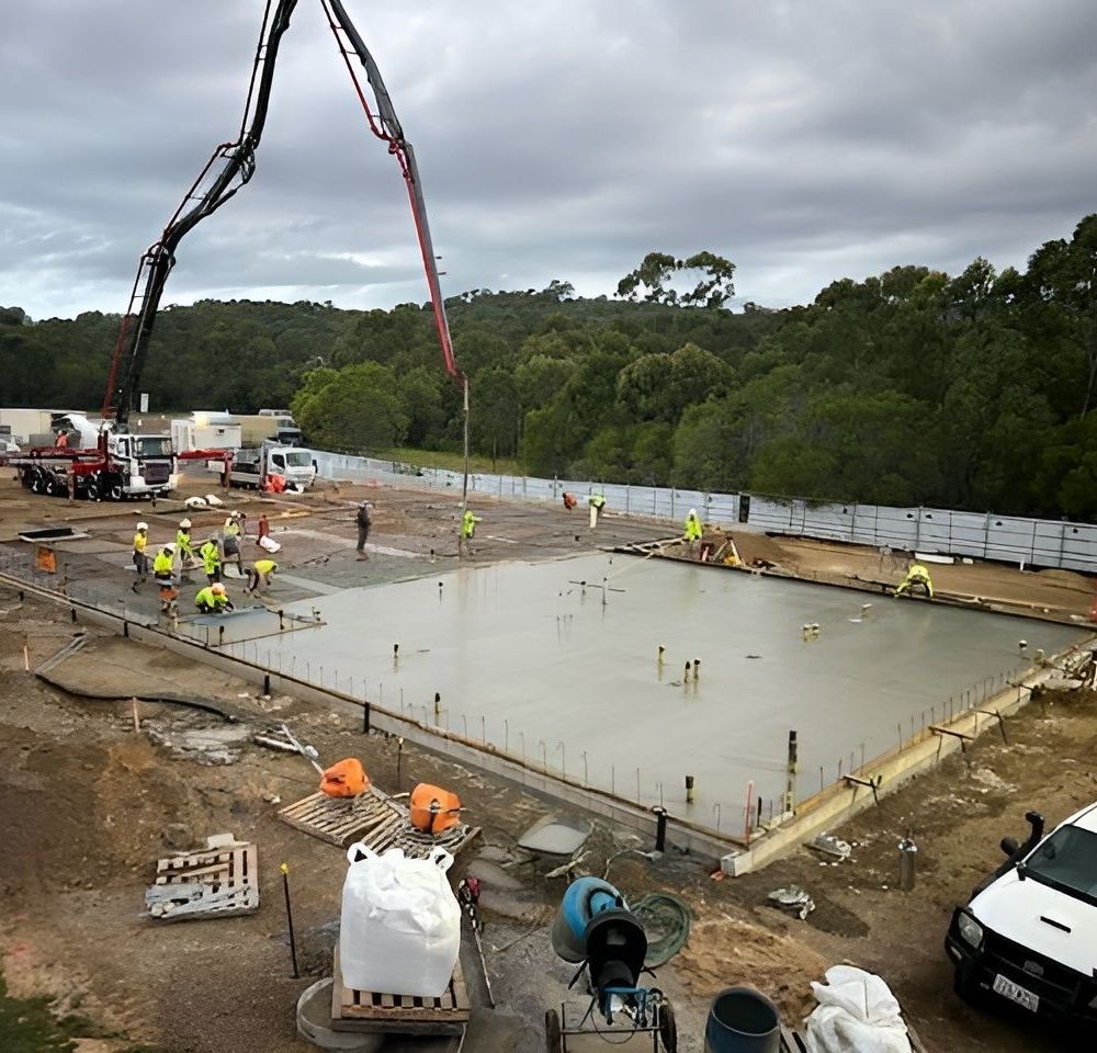 A Group Of Construction Workers Are Working On A Large Concrete Slab — CQBB Concreting Pumping Pty Ltd In Barmaryee, QLD