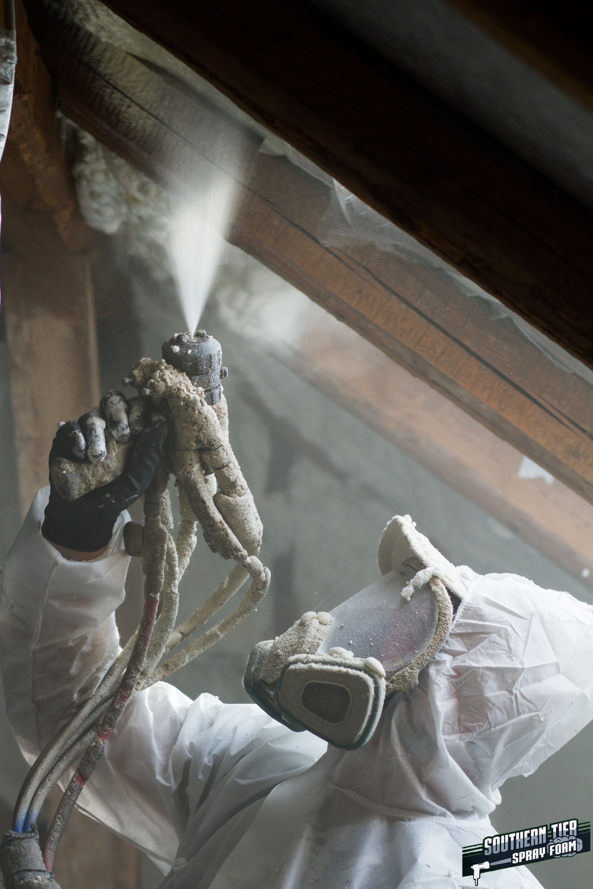 Workers applying spray foam insulation in a commercial building in Olean, NY
