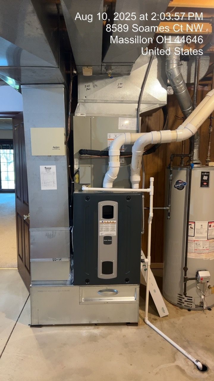 Furnace system with ductwork and water heater in a basement.