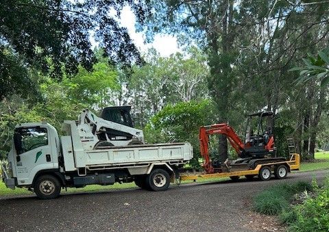 bobcat and excavator being transported