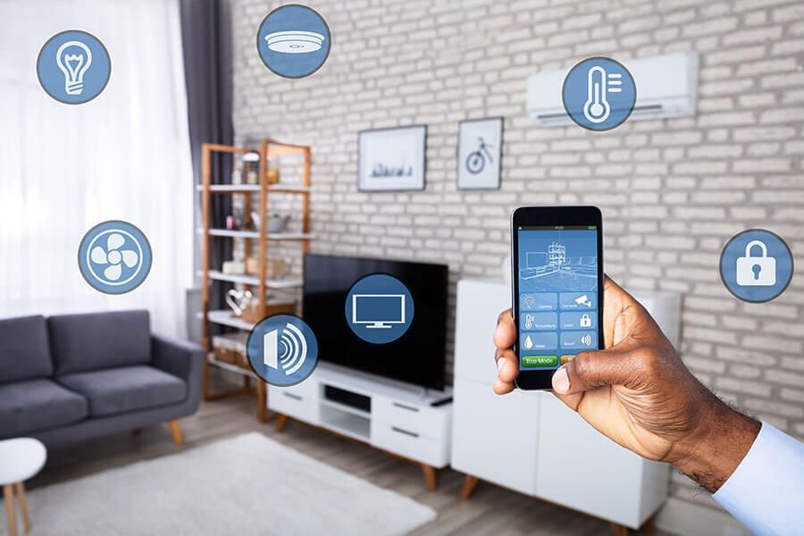A person is holding a smart phone in a living room.