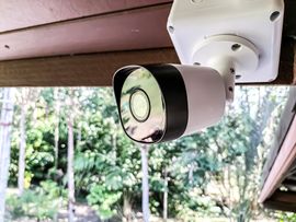 A security camera is mounted on the side of a building.