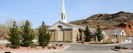 A church with a steeple and a mountain in the background