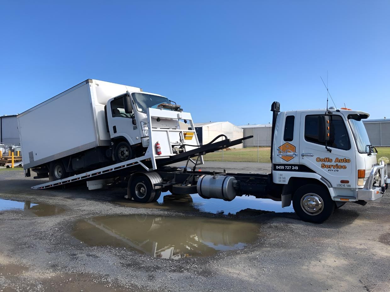 A White Truck is Being Towed by a Tow Truck — Coffs Tow Trucks In North Boambee Valley, NSW