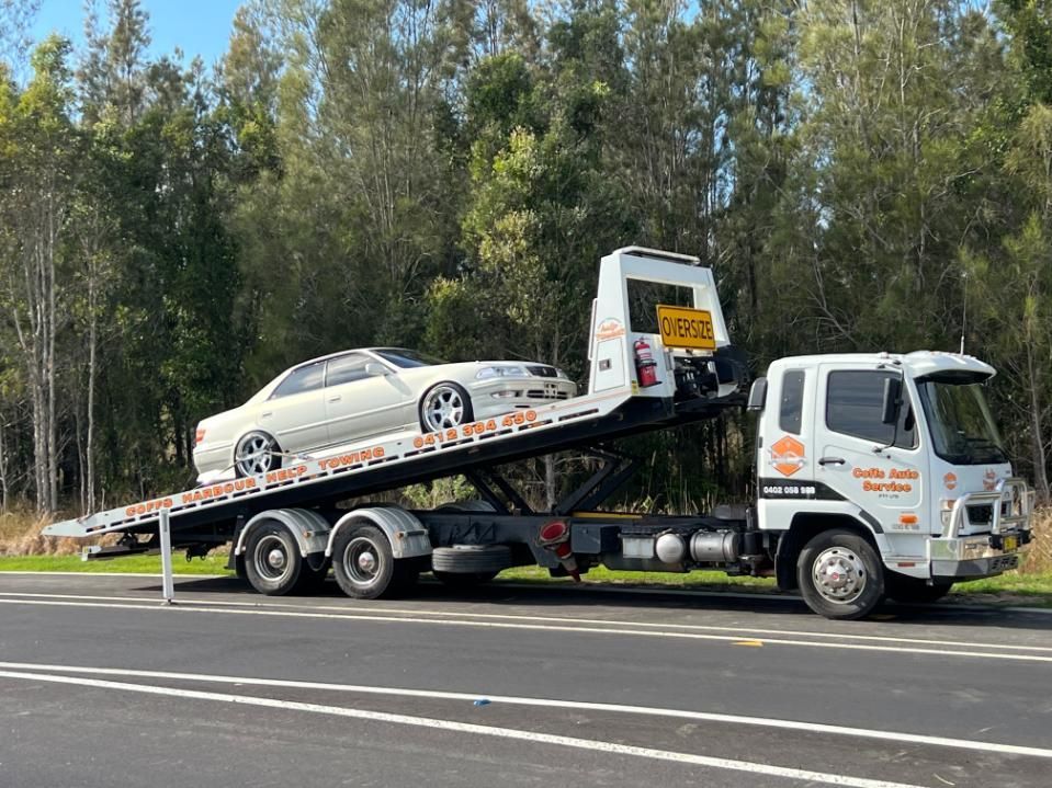 A Truck is towing car on roadside — Coffs Tow Trucks In North Boambee Valley, NSW