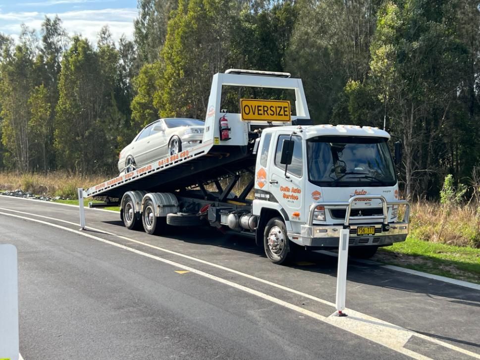 A Tow Truck is Towing a Car on the Side of the Road — Coffs Tow Trucks In Nambucca Heads, NSW