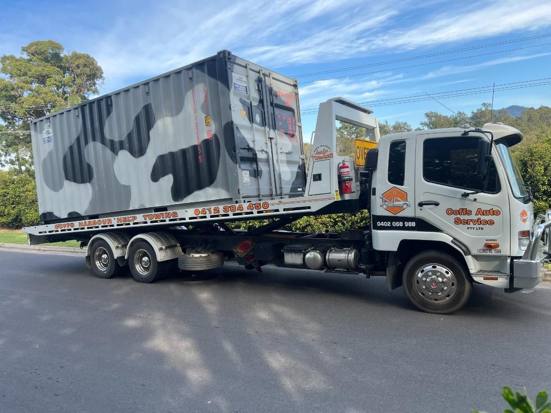A Tow Truck is Carrying a Container on the Back of It — Coffs Tow Trucks In North Boambee Valley, NSW
