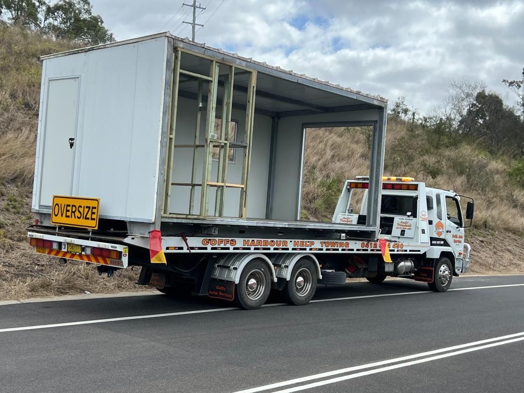 A Tow Truck is Carrying a White Box on the Back of It — Coffs Tow Trucks In Nambucca Heads, NSW