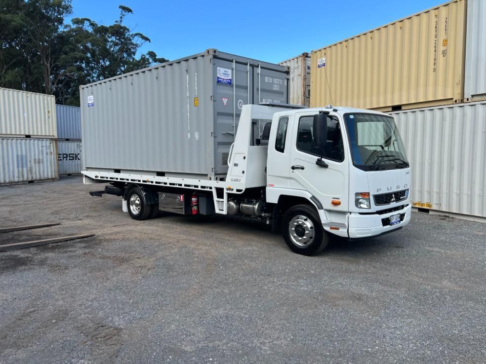 A White Truck With a Container on the Back is Parked in a Parking Lot — Coffs Tow Trucks In Macksville, NSW