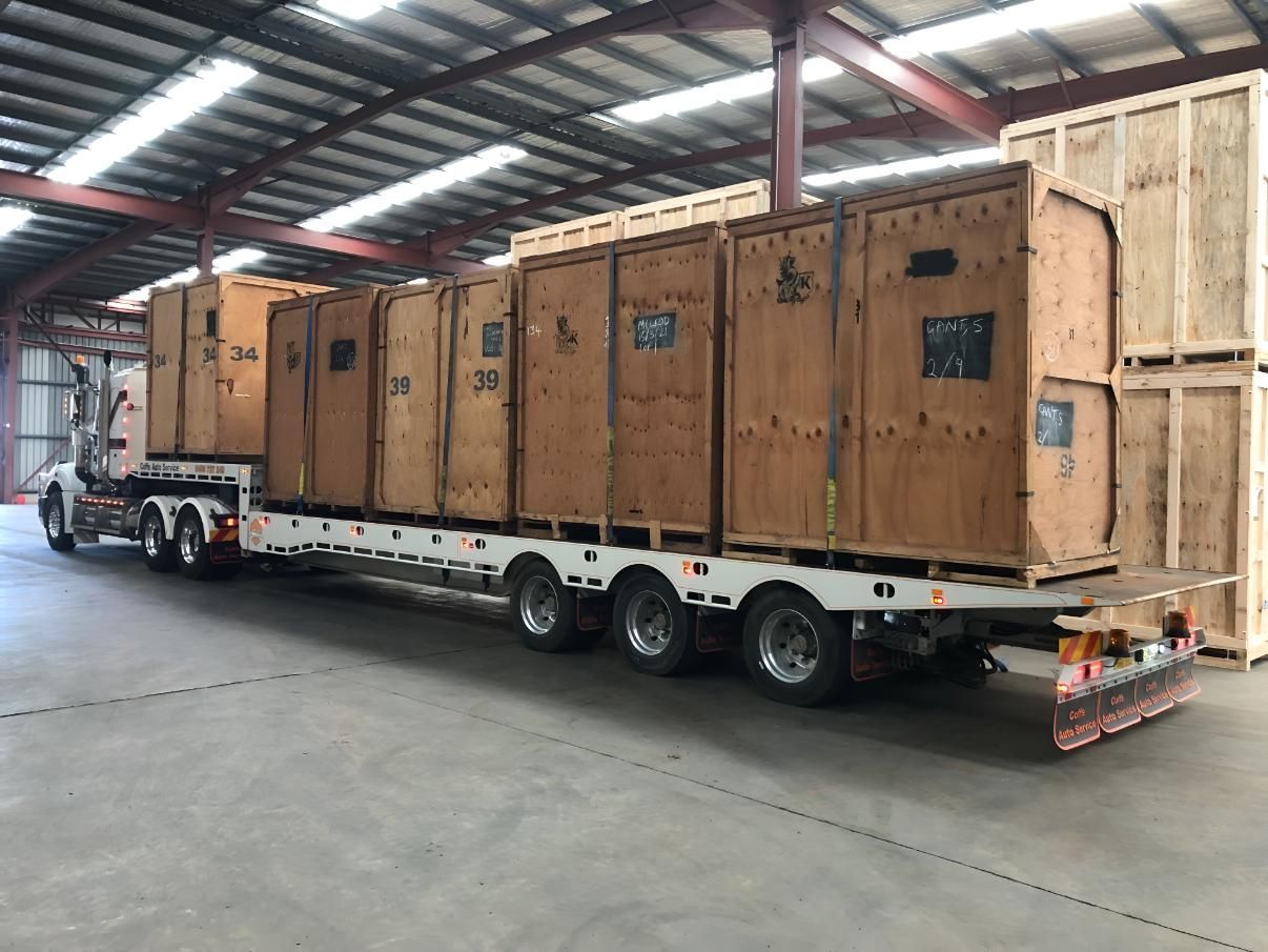 A Truck is Carrying Wooden Crates on a Trailer in a Warehouse — Coffs Tow Trucks In North Boambee Valley, NSW