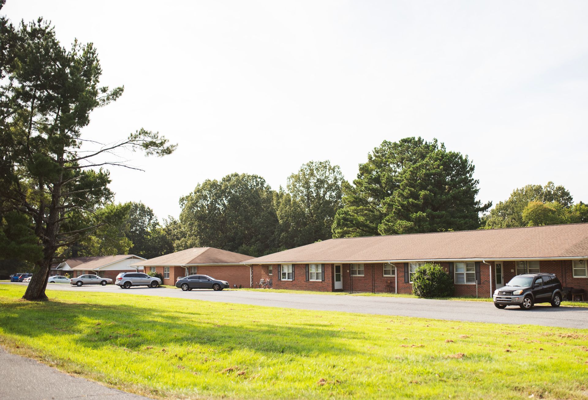 A row of brick houses with cars parked in front of them