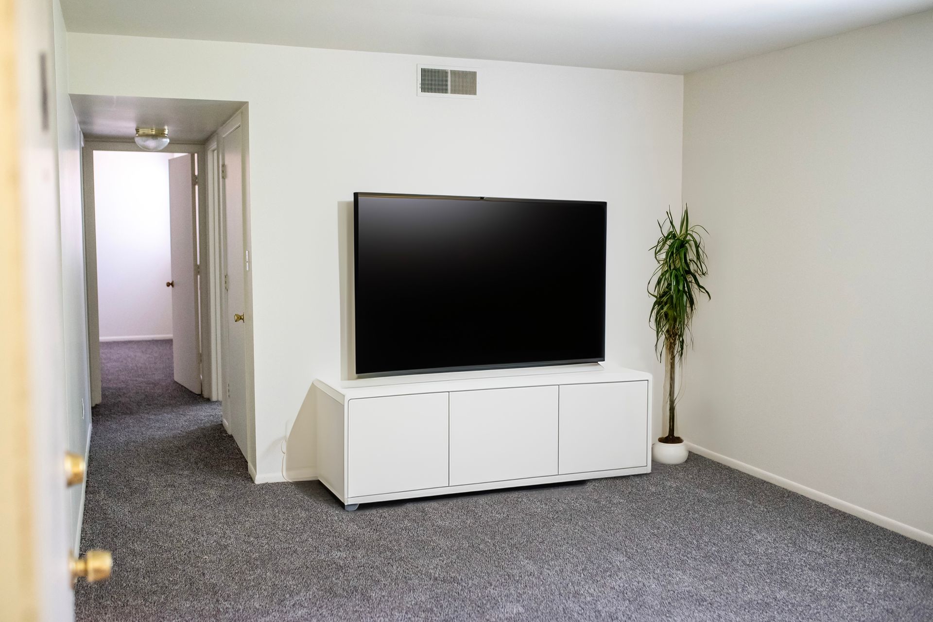 A living room with a flat screen tv on a stand.
