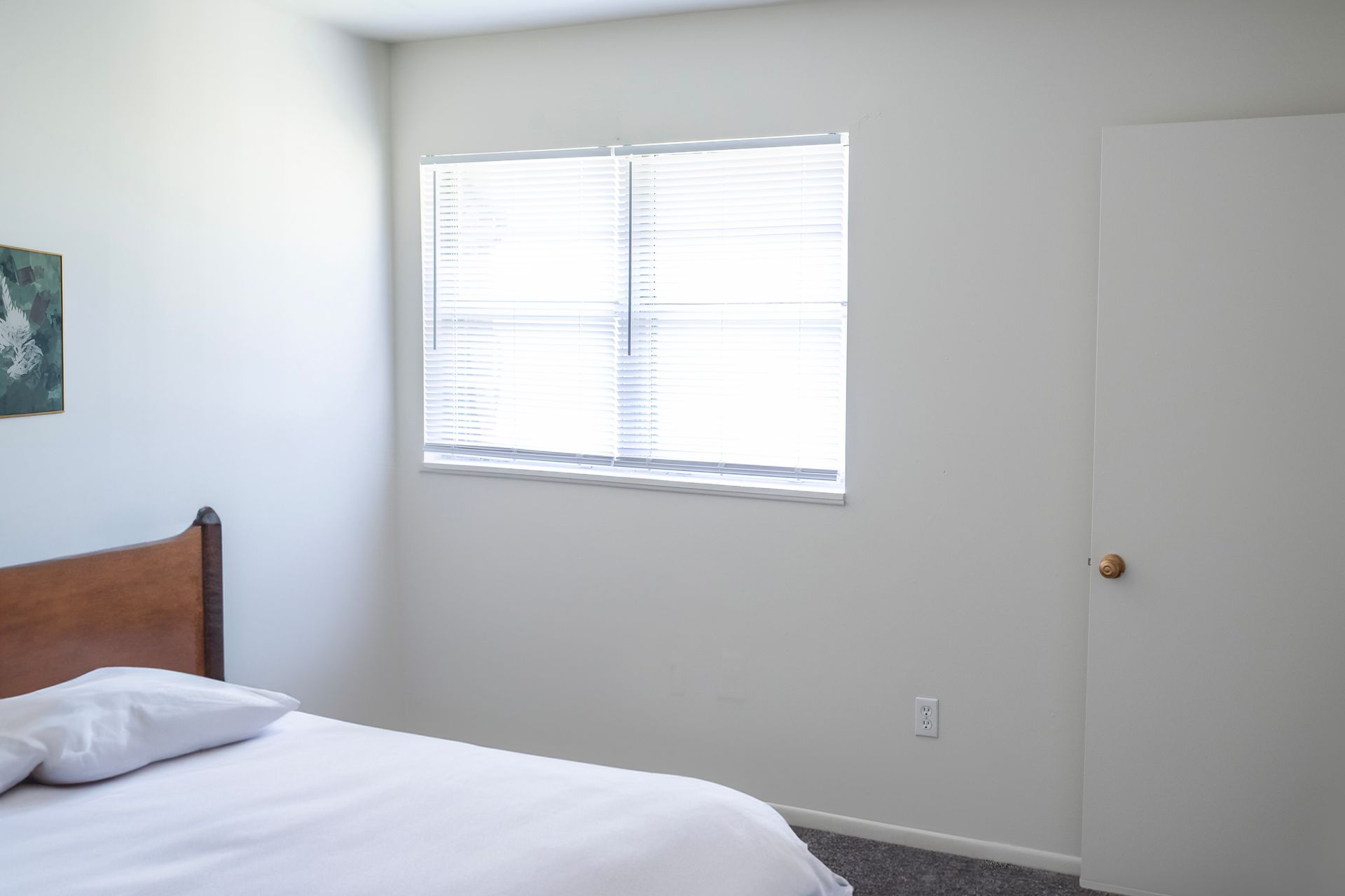 A bedroom with a bed , window and door