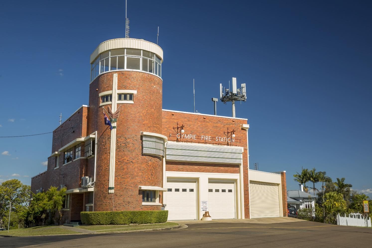 A Large Brick Building With A Tower And Antennas On Top Of It — X-Terminate Pest Control In Gympie, QLD