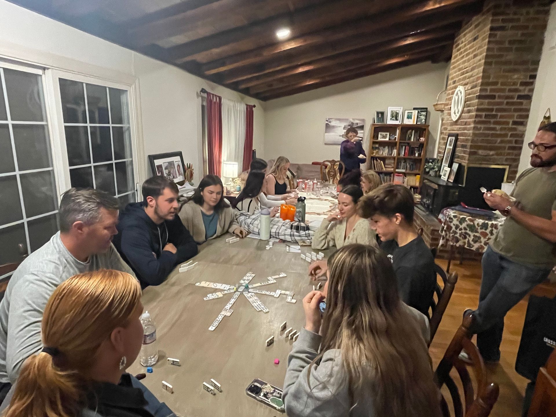 A group of people are sitting around a table playing cards.