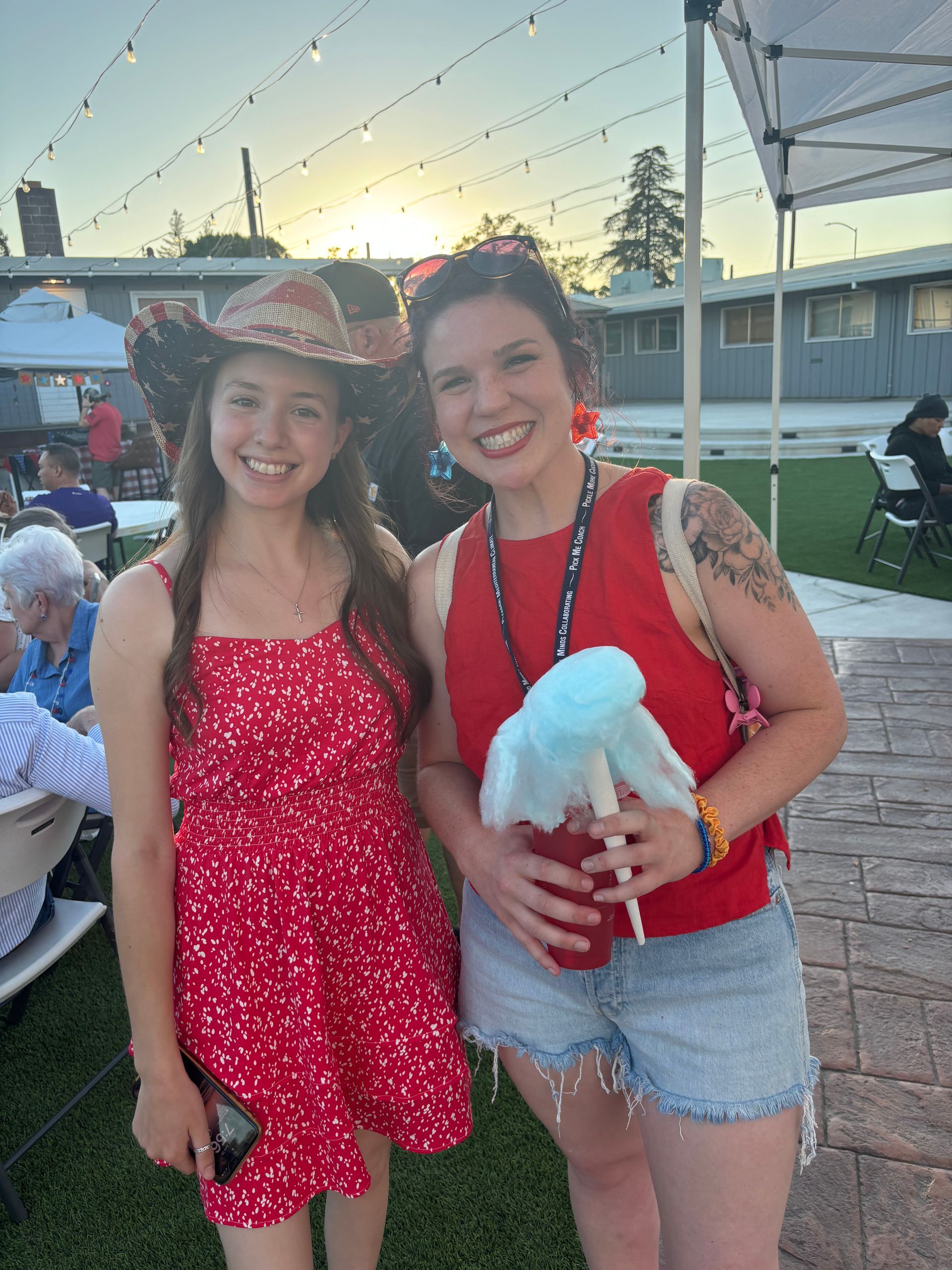 Two women are standing next to each other holding cotton candy.