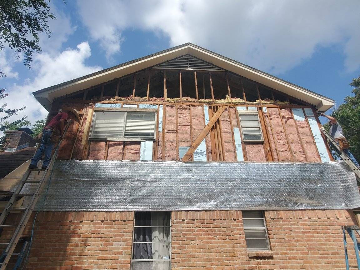 A brick house with a roof that is being remodeled