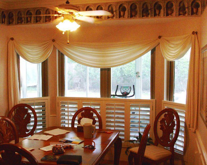 A dining room with a table and chairs and a ceiling fan