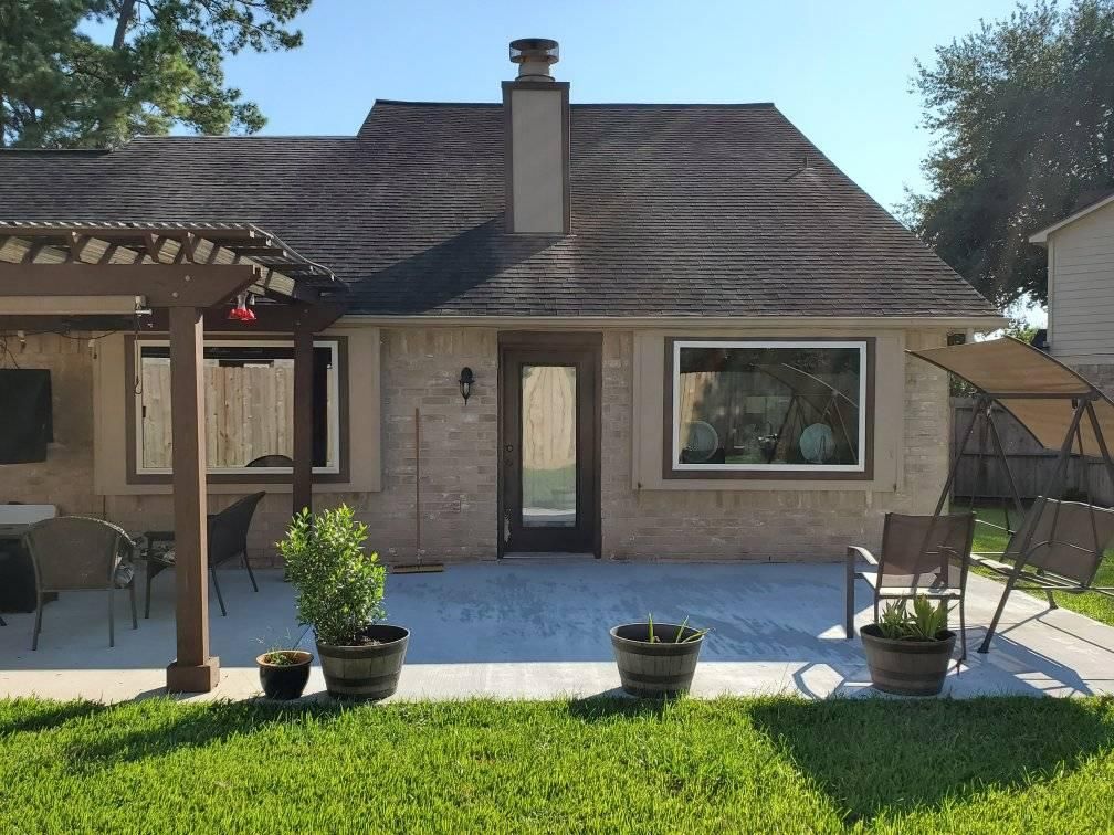 The backyard of a house with a swing and potted plants