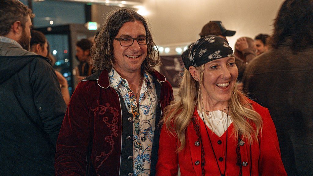 A man and a woman are standing next to each other in a crowd of people.