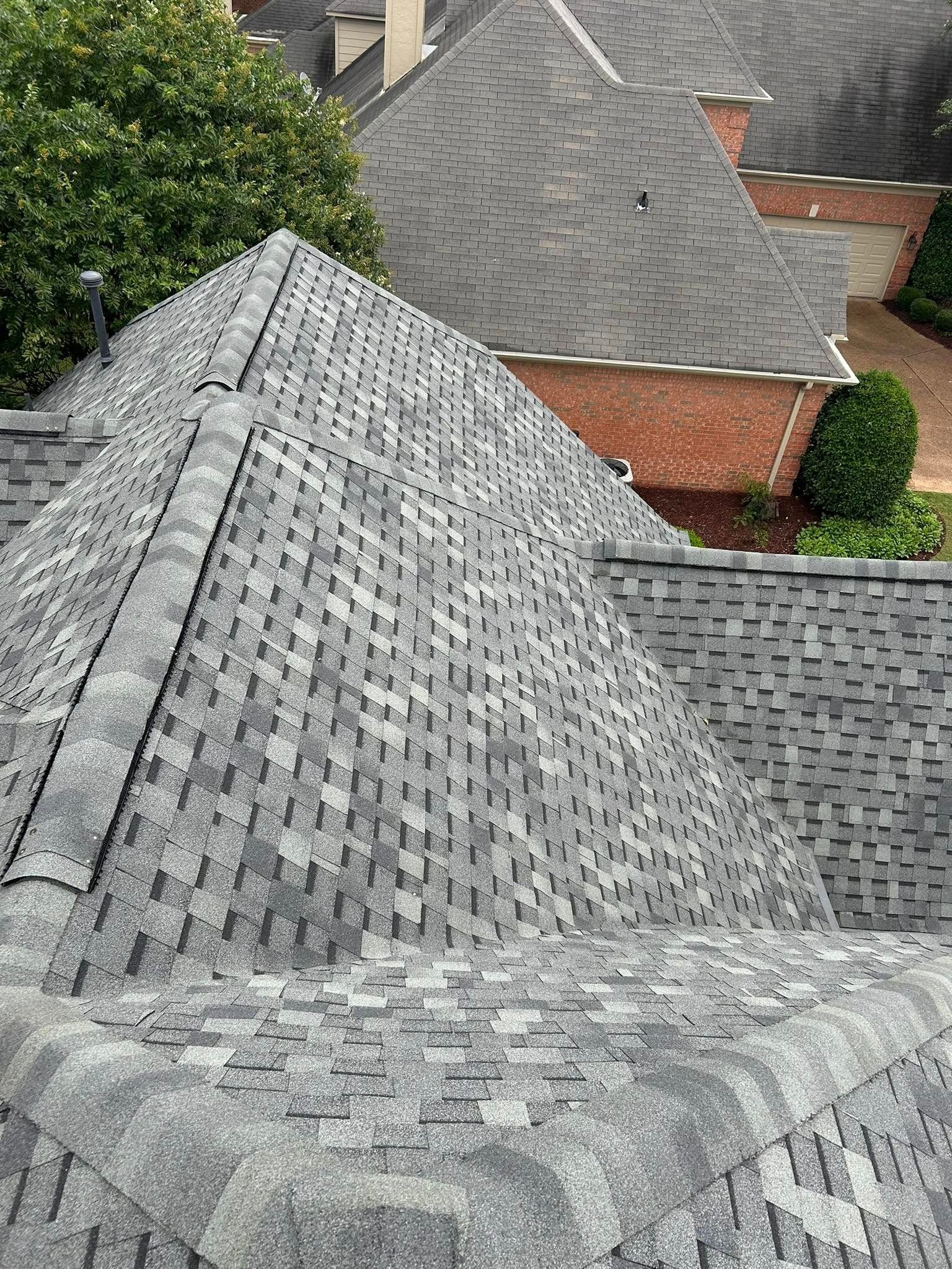 Overhead view of a roof covered in gray asphalt shingles.
