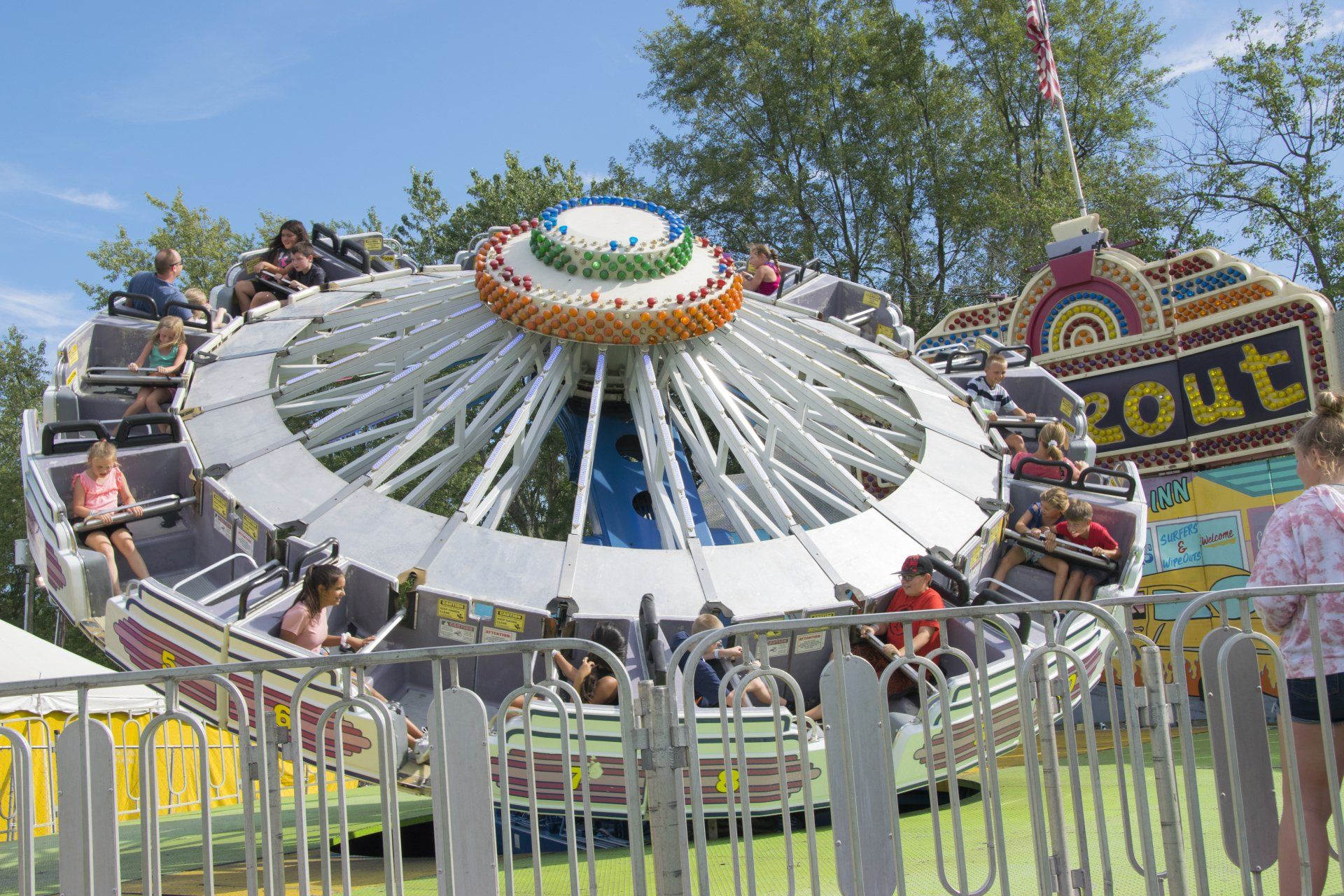 People riding a merry go round with a sign that says zout