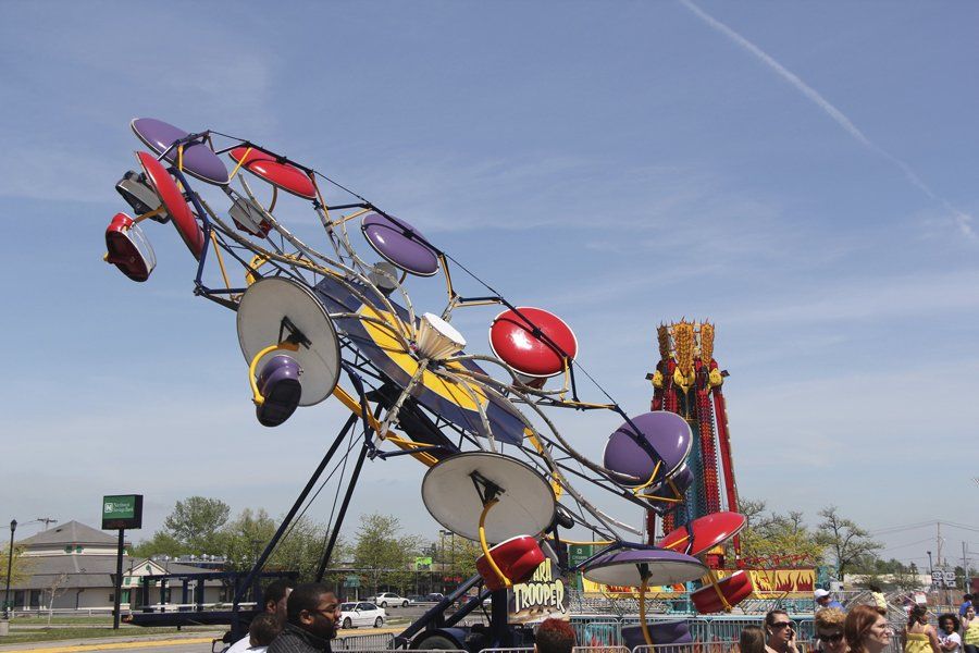 A ferris wheel at a carnival with people watching