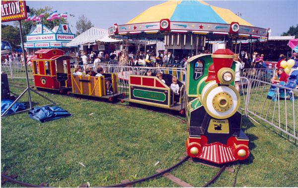 A group of children are riding a train at a carnival