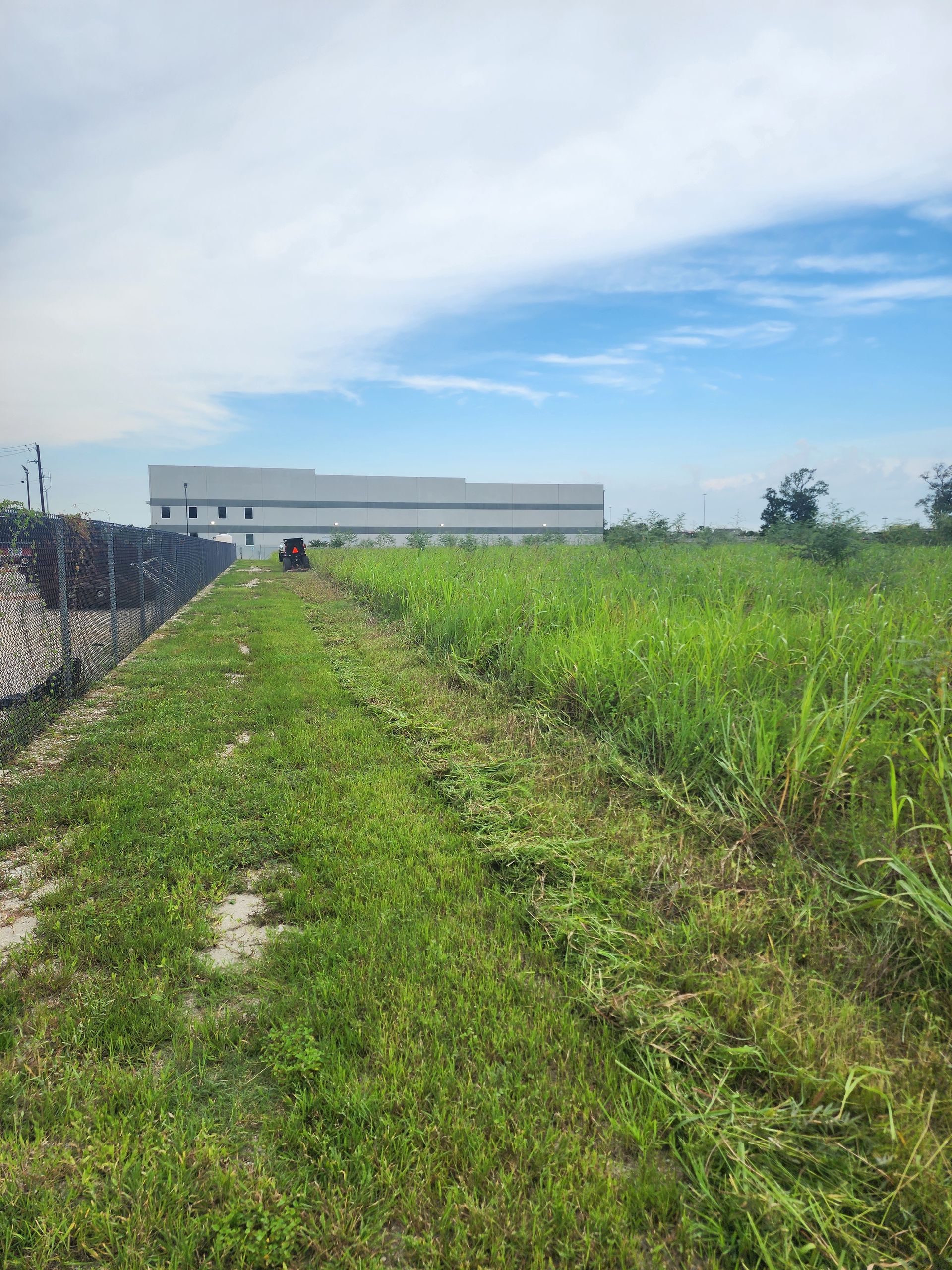 A large grassy field with a building in the background