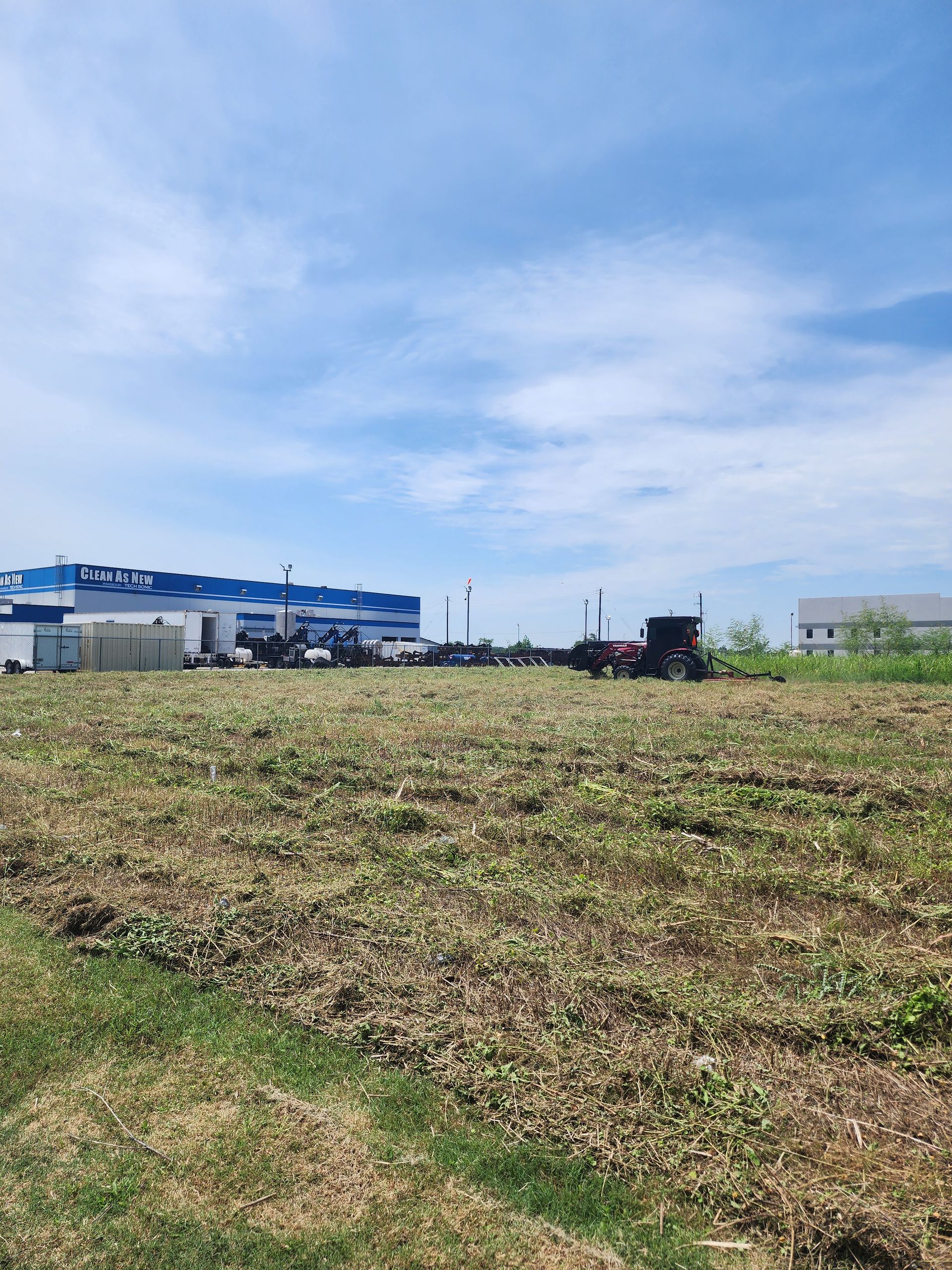 A road going through a grassy field on a sunny day
