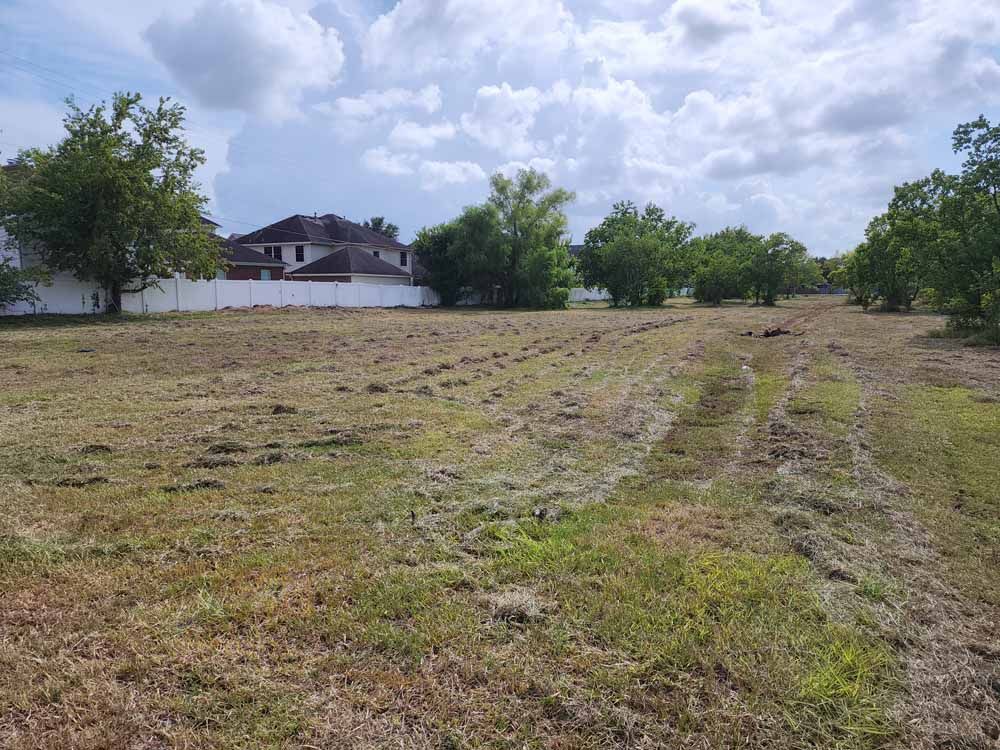 A large grassy field with a house in the background