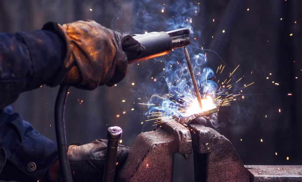 A Man Welding A Metal Component For Farm Equipment