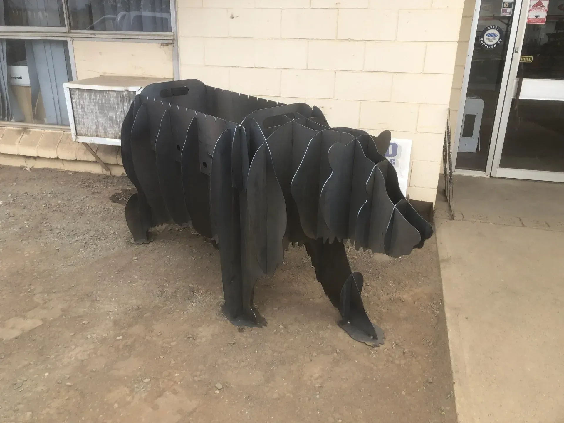 A Bear Made Out Of Tires Is Standing In Front Of A Building — Agriweld Engineering in Dubbo, NSW