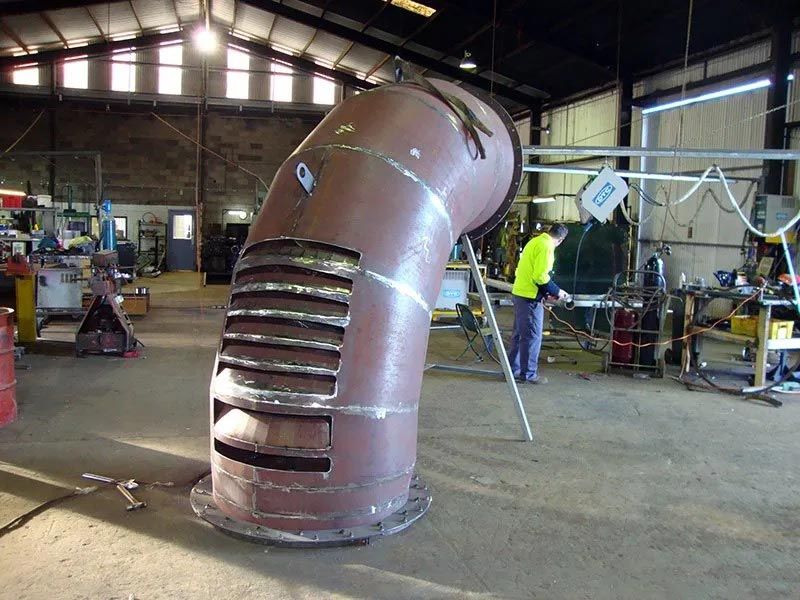 A Man Is Welding A Metal Structure In A Factory — Agriweld Engineering in Dubbo, NSW