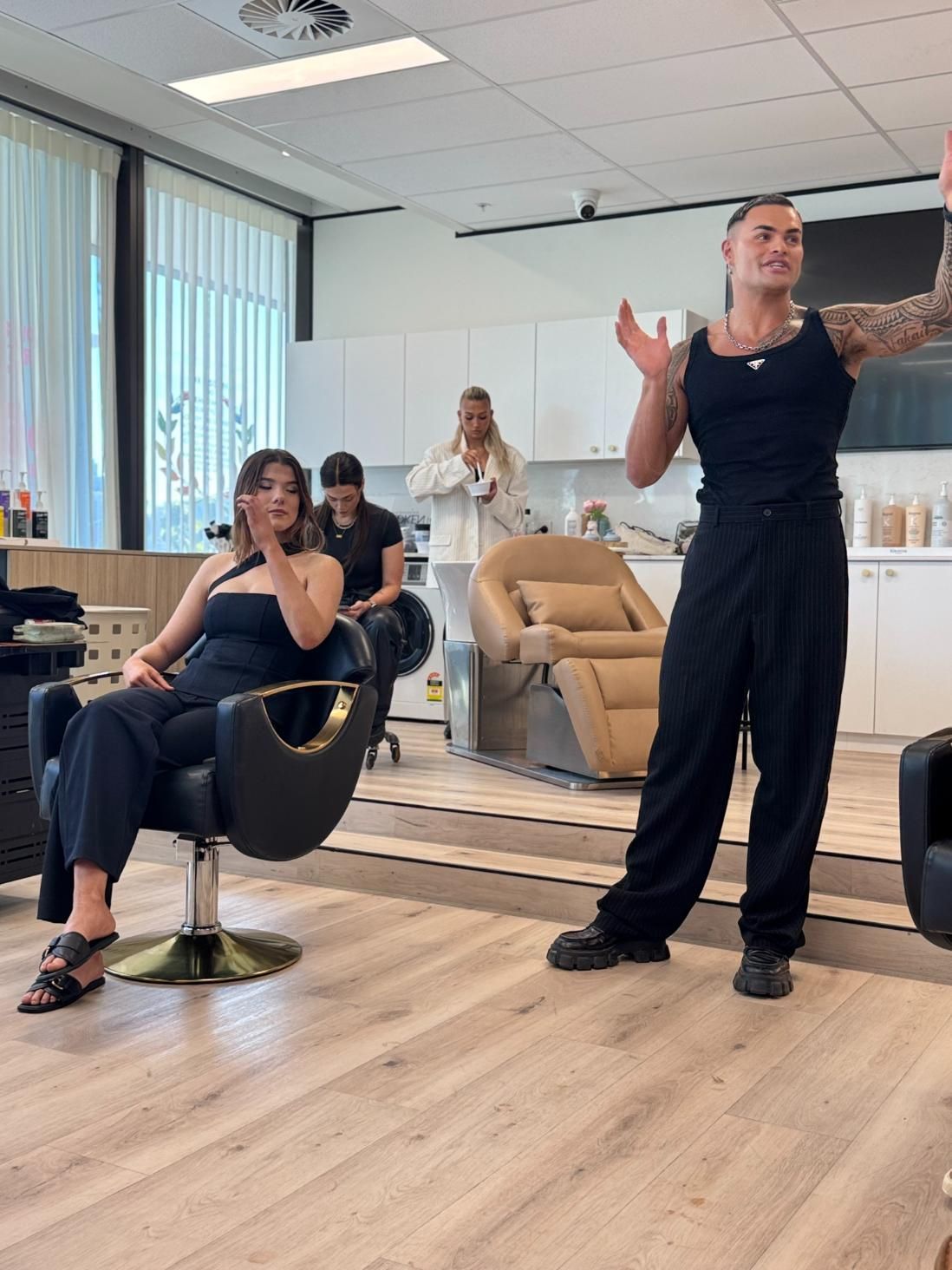A Person Gestures in a Salon, With a Woman Seated — Gina T Hair & Beauty In Mackay, QLD
