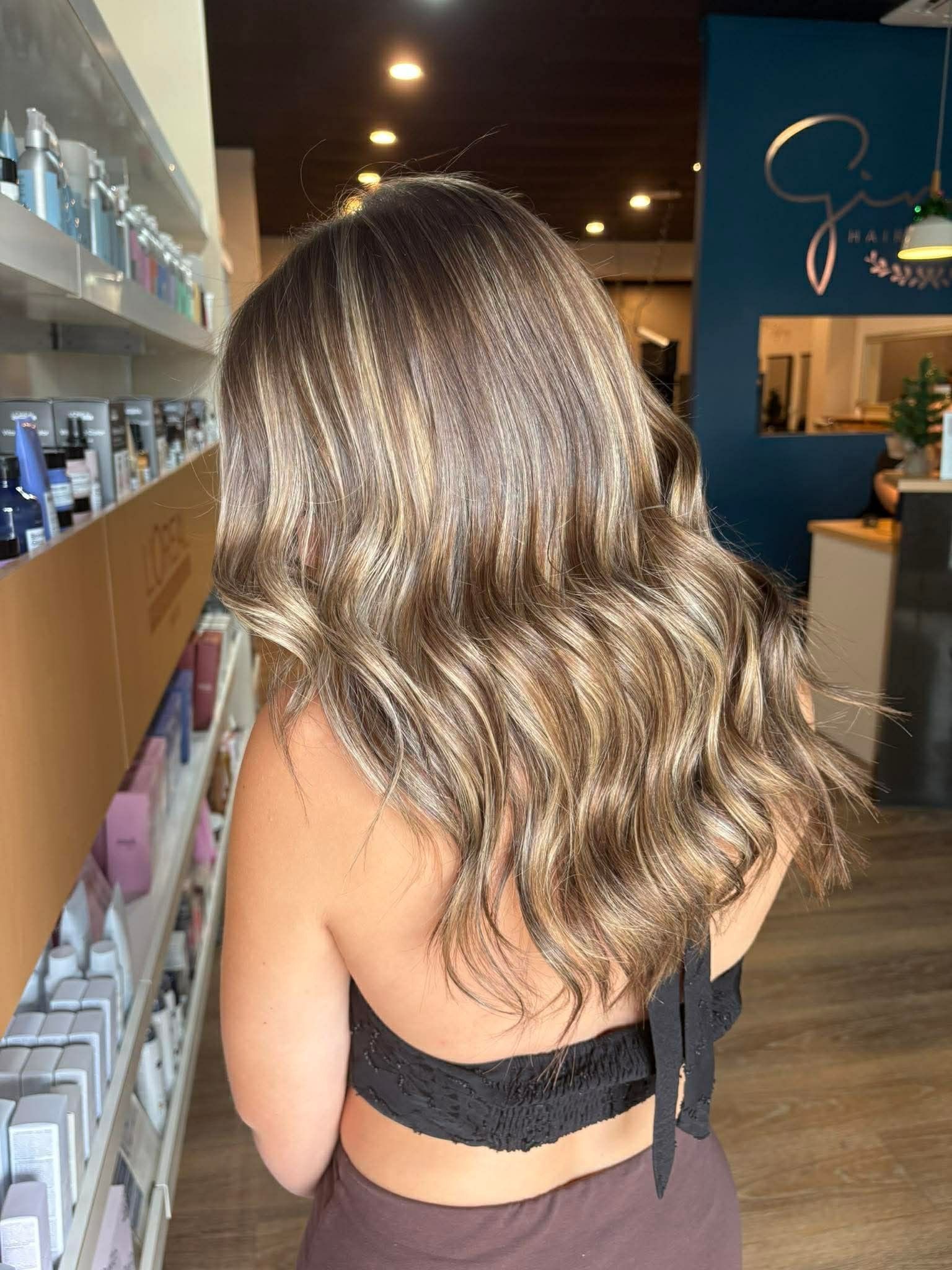 Woman With Long, Wavy, Ash-blonde Hair In A Salon — Gina T Hair & Beauty In Mackay, QLD