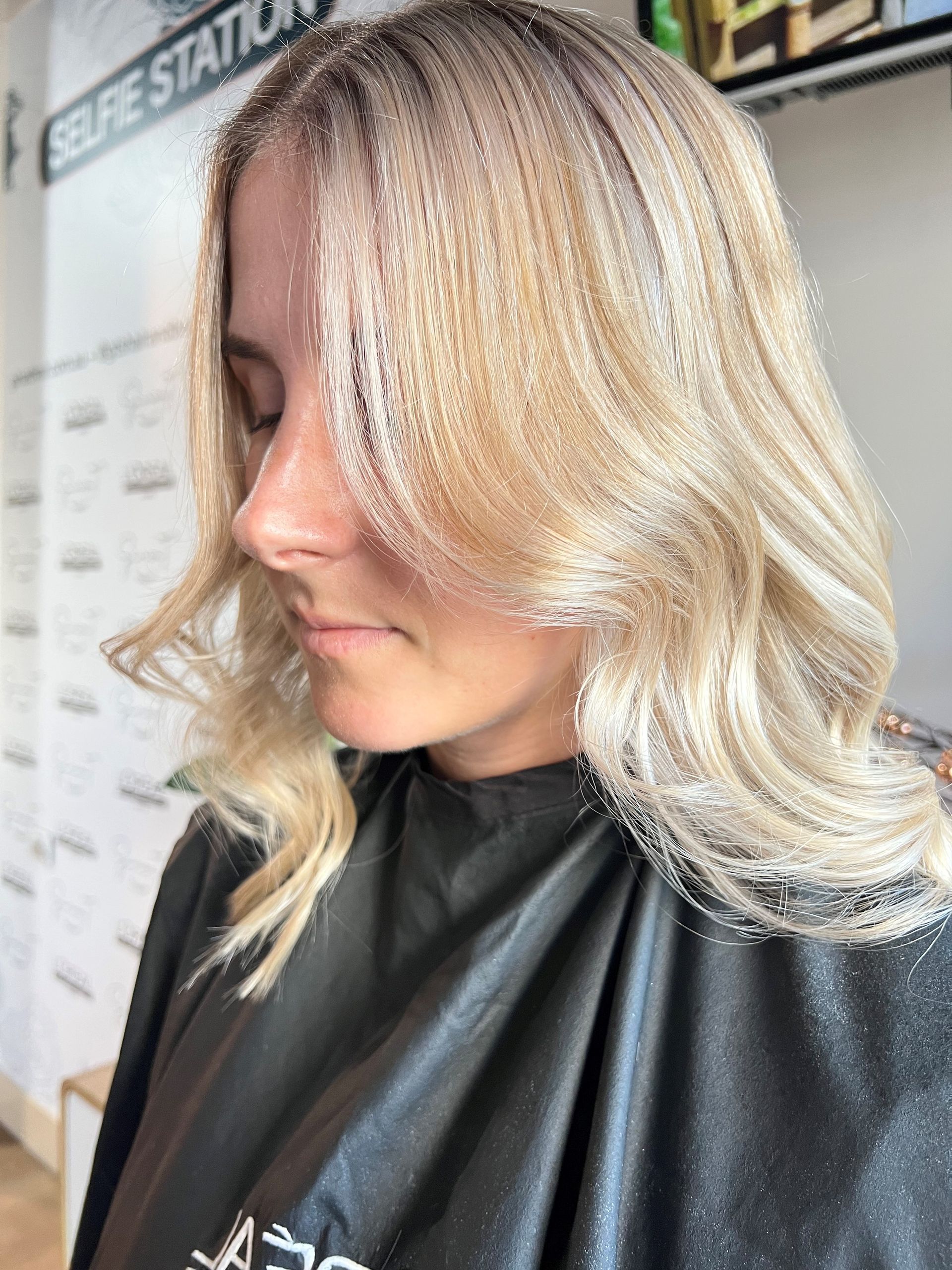 Woman With Wavy Blonde Hair, Wearing A Black Salon Cape — Gina T Hair & Beauty In Mackay, QLD