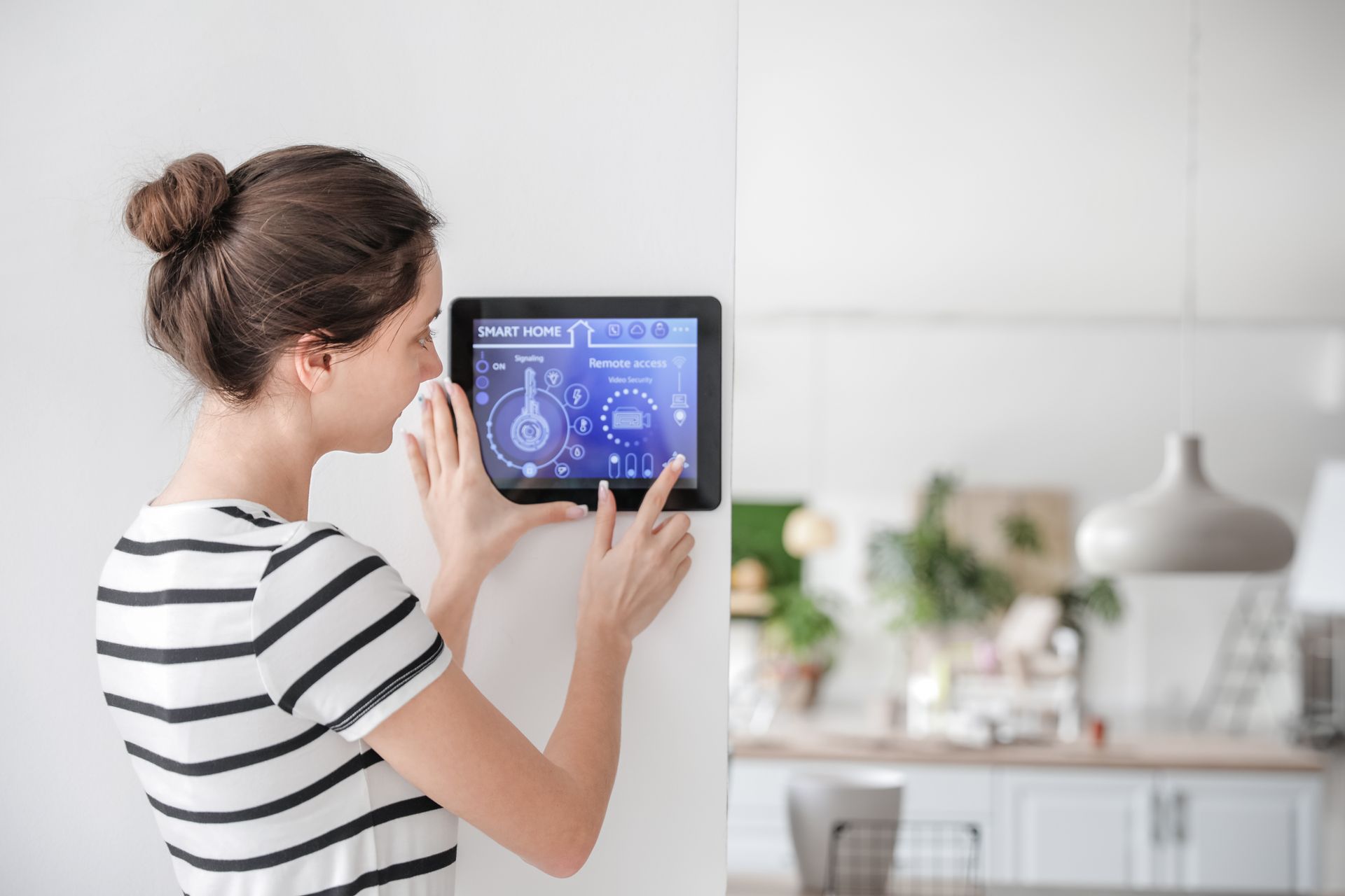 Woman managing home security through a smart control panel.