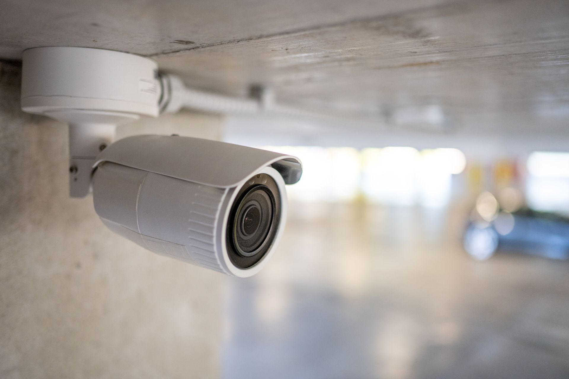 A surveillance camera keeping an underground parking space secure.