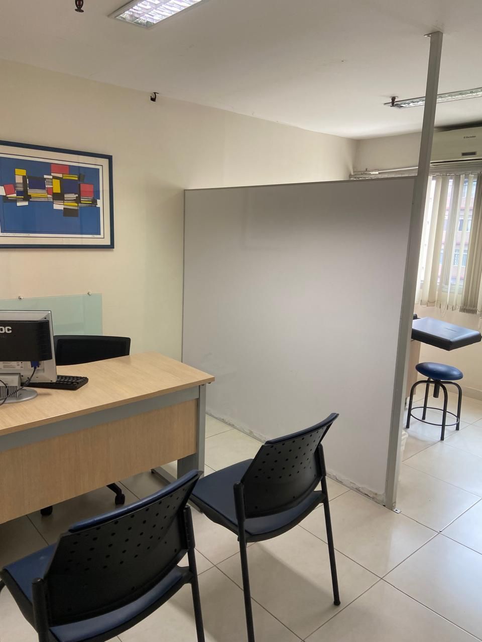 Duas cadeiras estão sentadas em frente a uma mesa com um computador sobre ela.