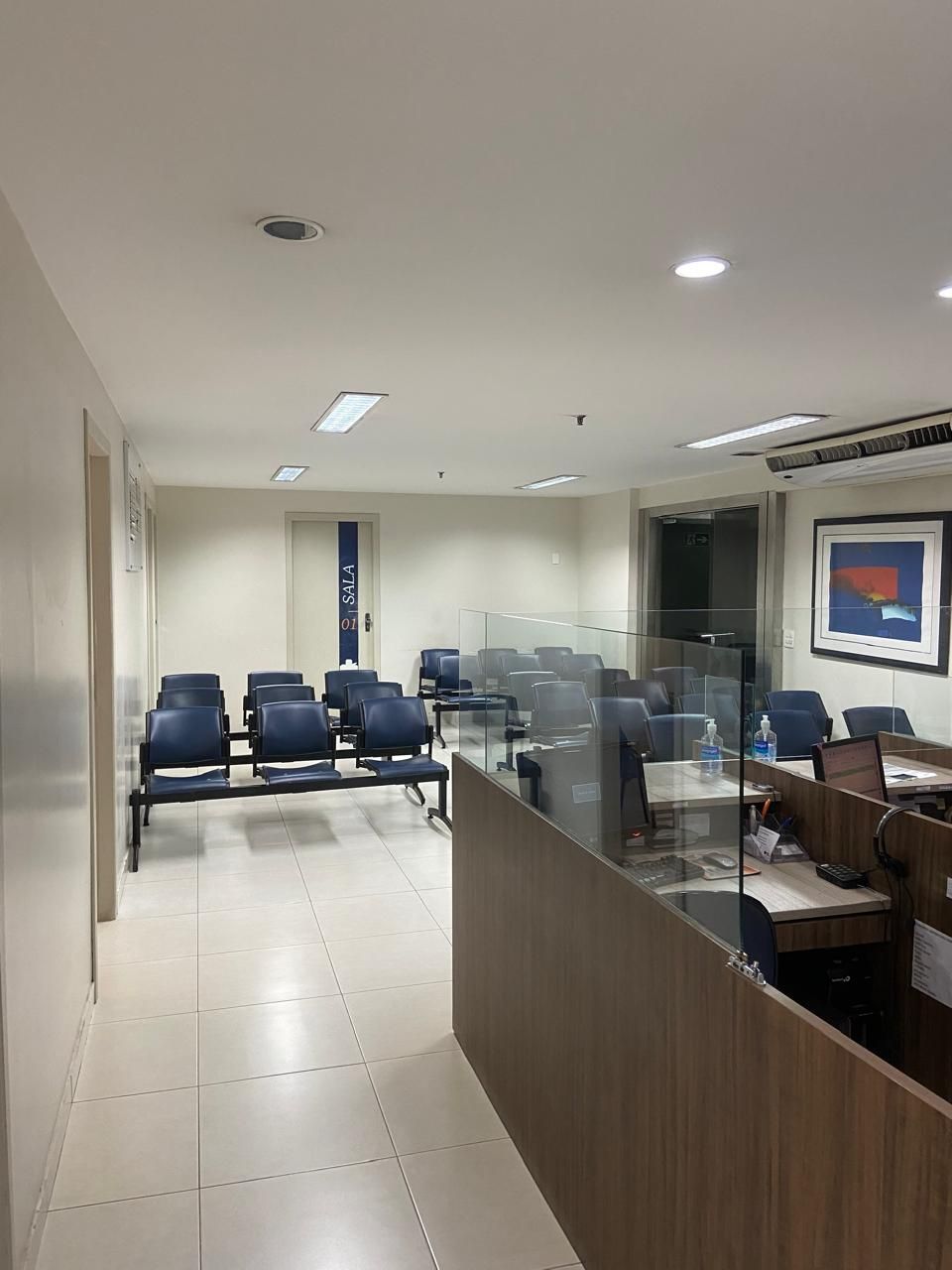 Uma sala de espera com muitas cadeiras e mesas.