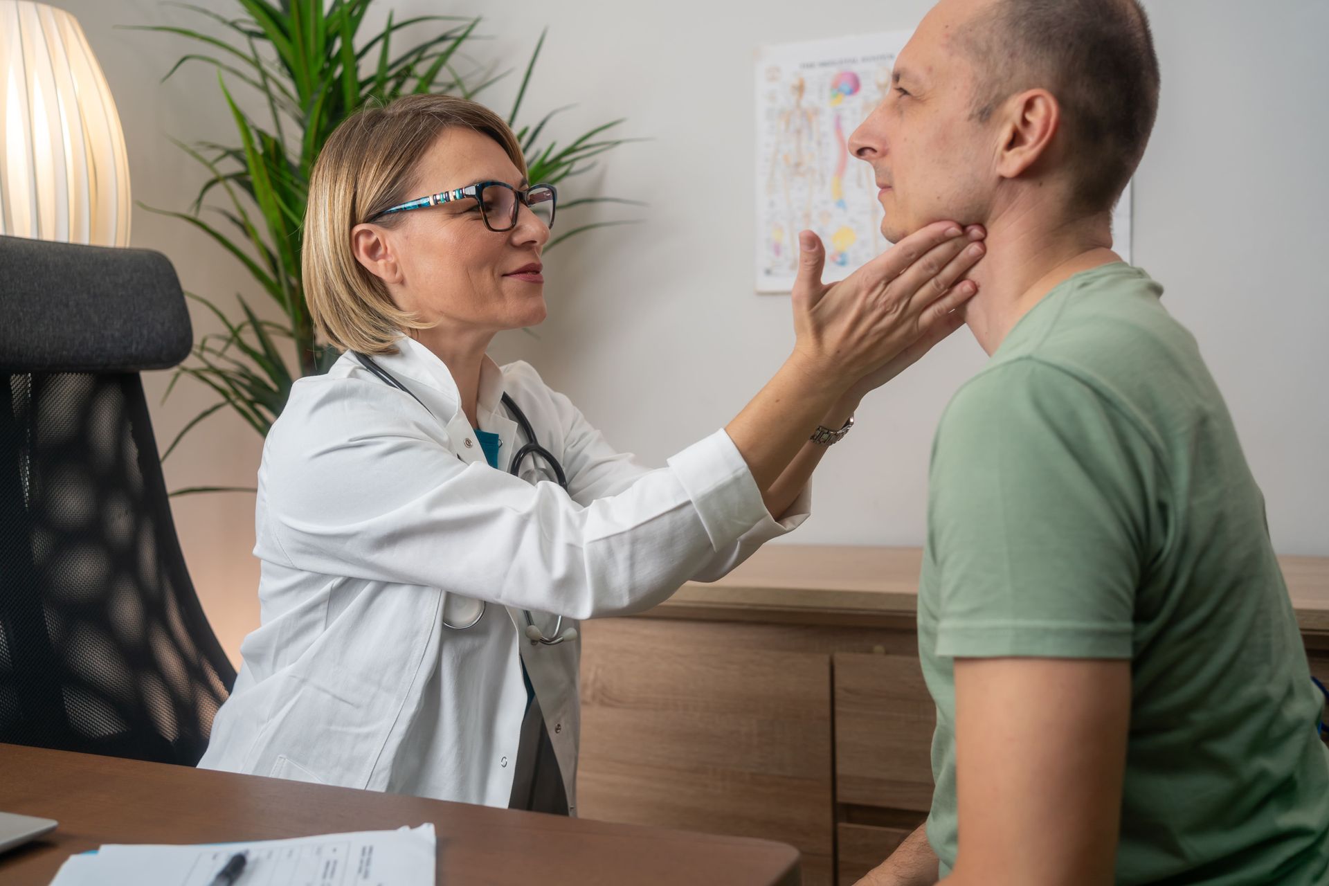 Um médico está examinando a glândula tireoide de um homem em um hospital.
