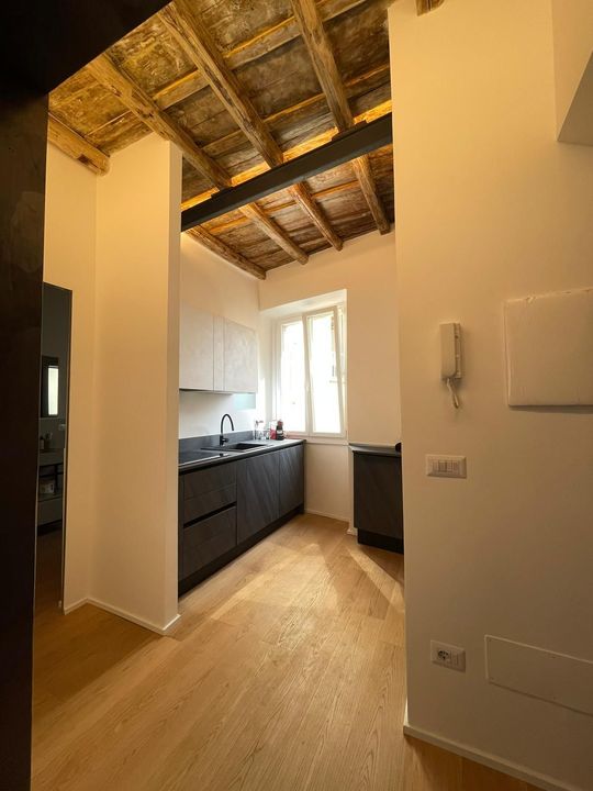 Due operai sigillano un tetto; sullo sfondo la città.