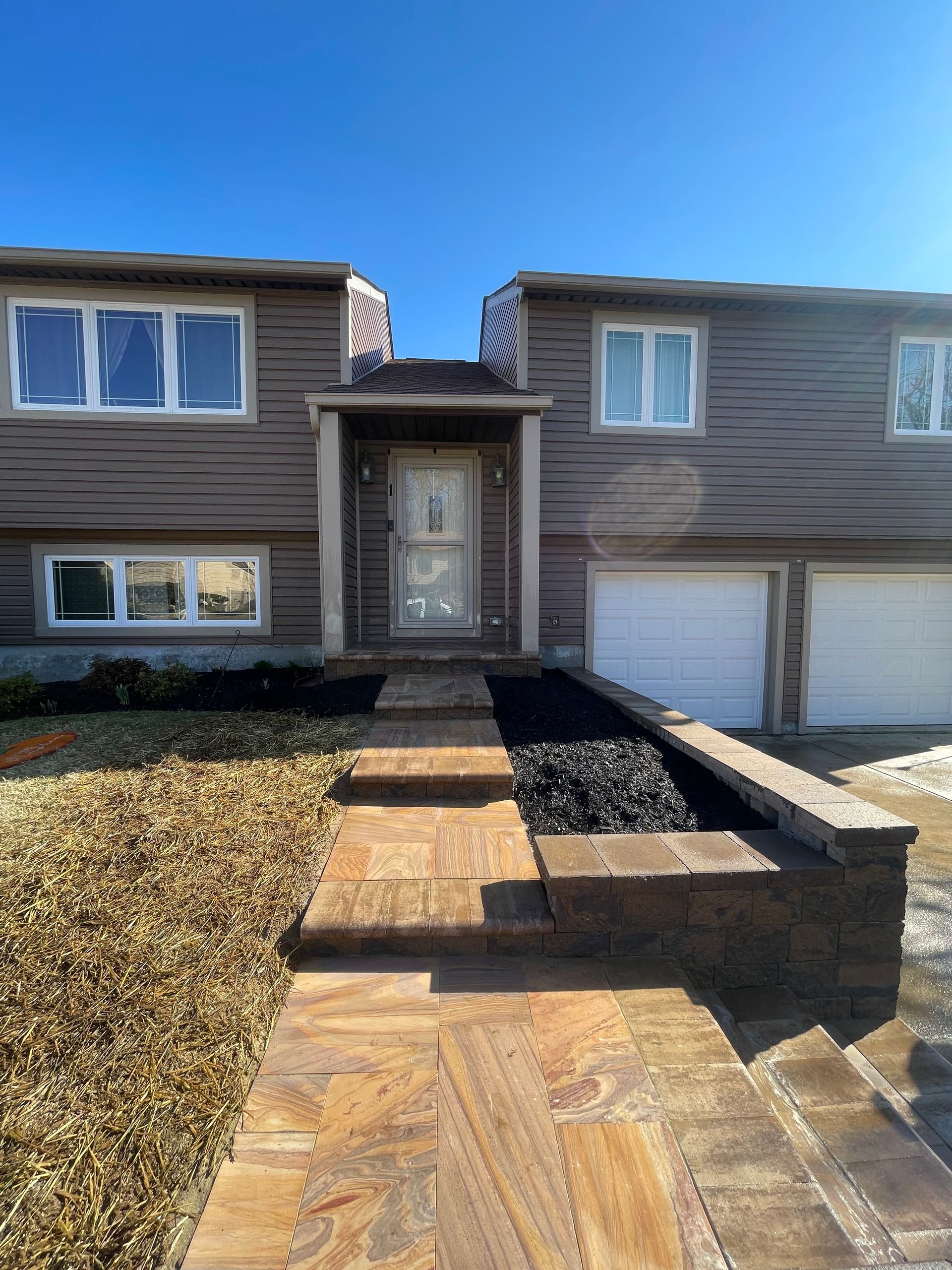 A large house with a walkway leading to the front door.