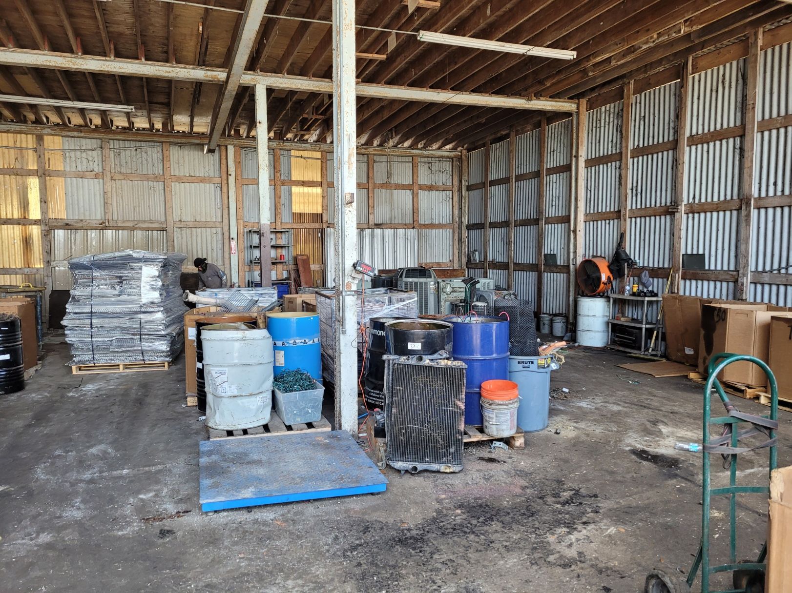 A large warehouse filled with lots of barrels and boxes.